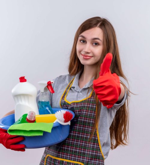 hermosa-joven-delantal-guantes-goma-lavabo-herramientas-limpieza-sonriendo-mostrando-pulgares-arriba (1)